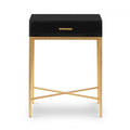 Black side table with a drawer and brass finish legs on a white background