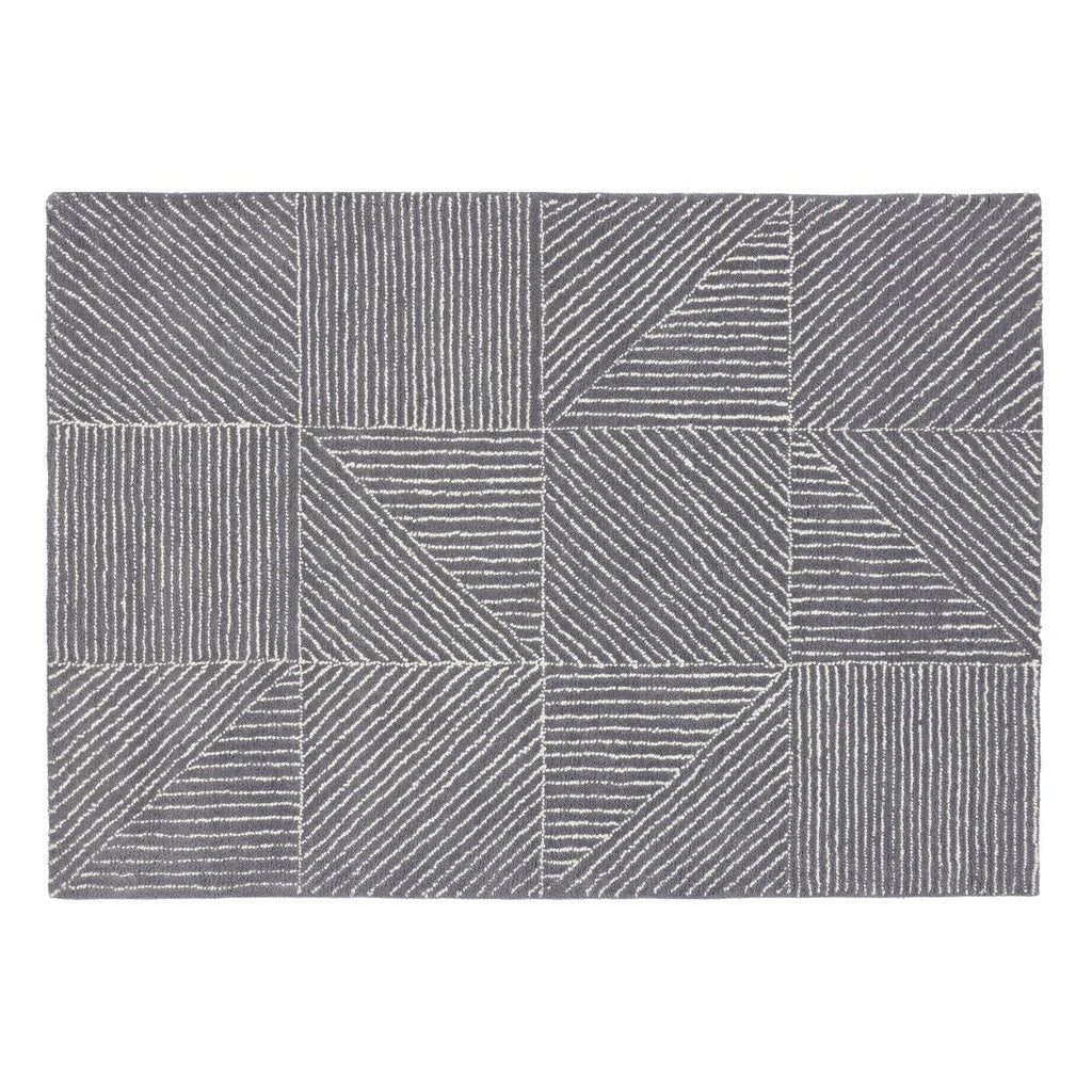 A rectangular area rug with a modern geometric pattern of gray and white blocks, lines, and triangles, shown flat against a white background.