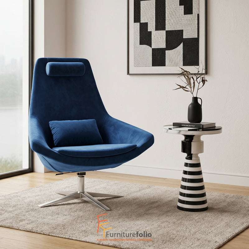 Modern blue armchair in a stylish living room with a side table and abstract art.